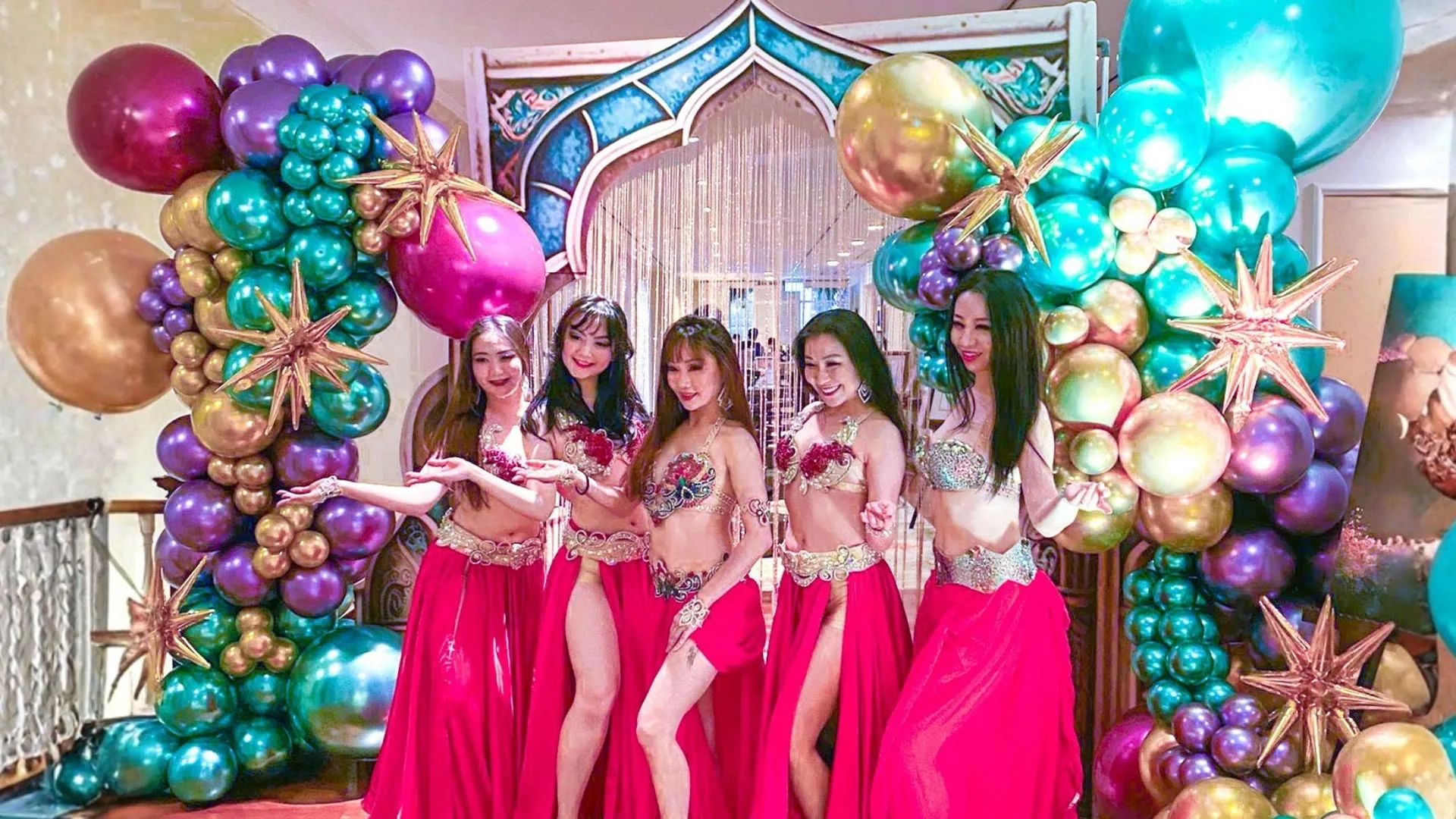 Costumed performers posing in front of a colourful corporate dinner and dance photo wall