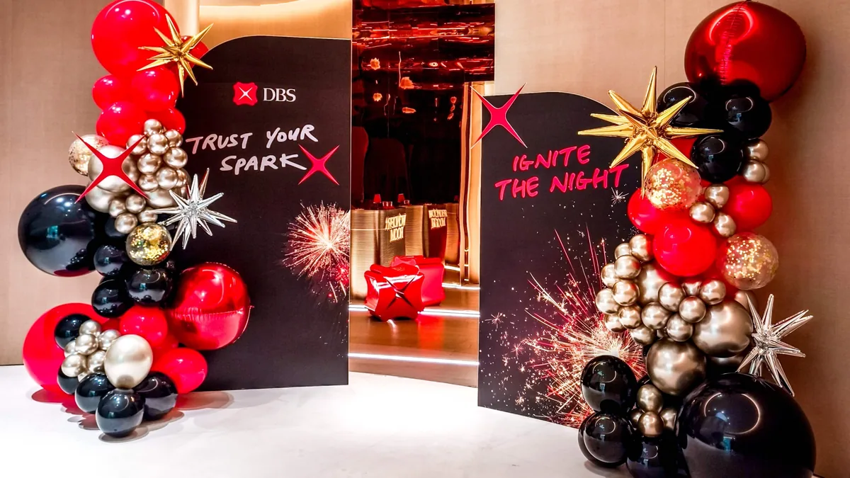 Branded event entrance backdrop with balloon garland and star details, styled by The Happier Event Company